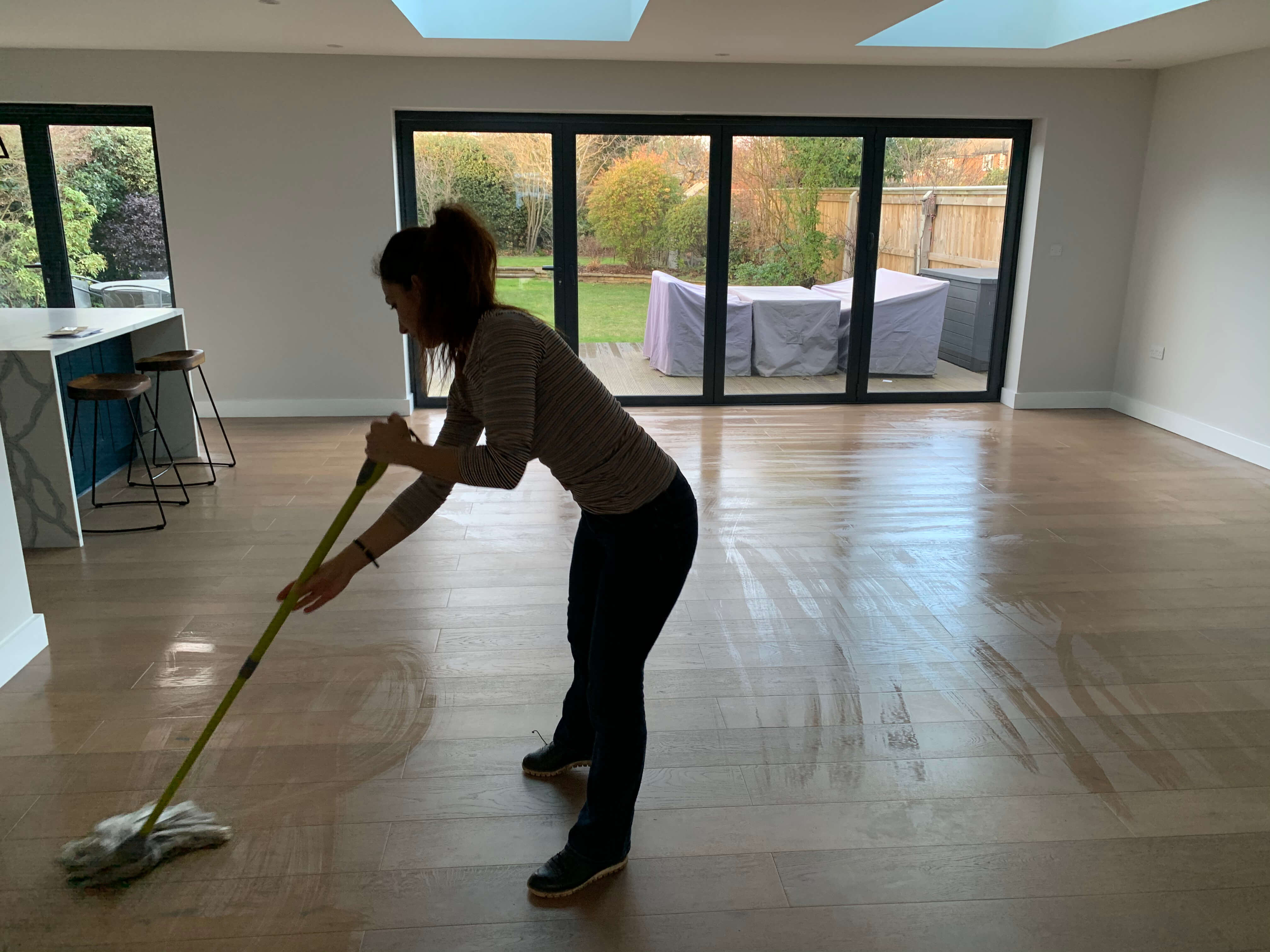 cleaning lady mopping a floor during an end of tenancy cleaning service near twickenham