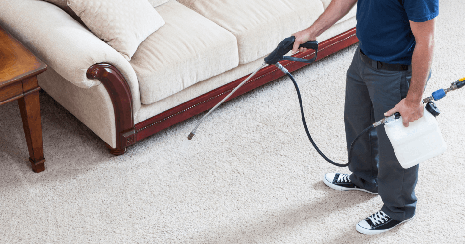 man is using a prespray product on carpet before cleaning