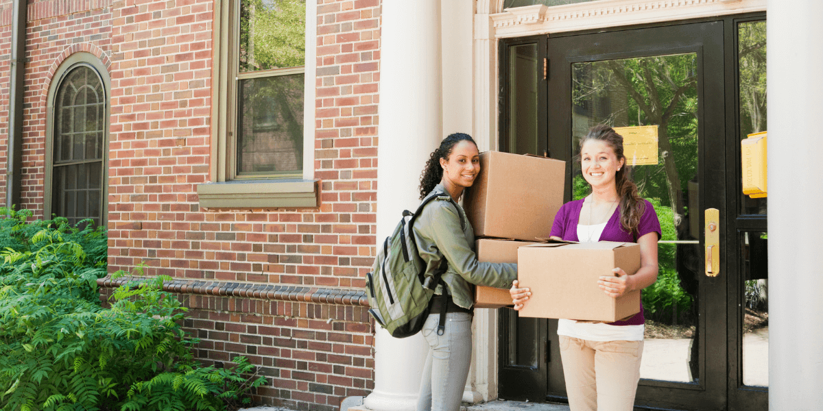 two girls students lift a boxes before an end of tenancy cleaning service